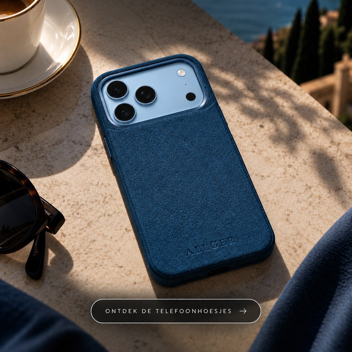 Blauw Alcantara telefoonhoesje van Allgèr op een terras aan zee